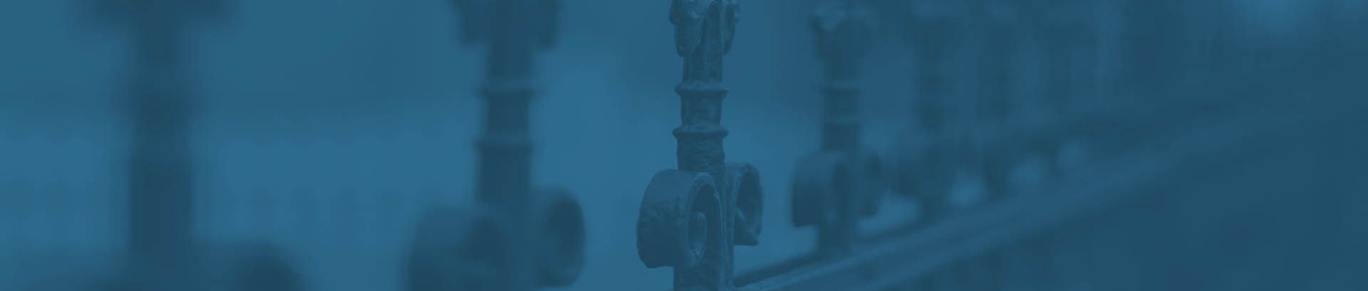 Ornate railings in the design of a Fleur di Lis in blue
